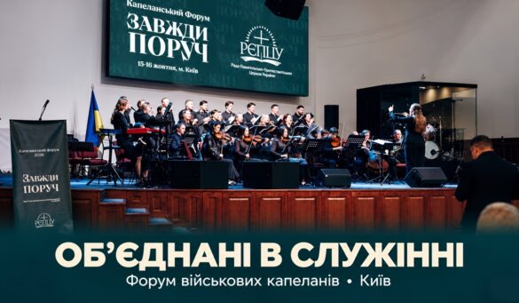 Військові капелани на Форумі в Києві — хор і оркестр на сцені під екраном «Капеланський форум. Завжди поруч. 15–16 жовтня, м. Київ»; унизу напис «Об’єднані в служінні. Форум військових капеланів • Київ»